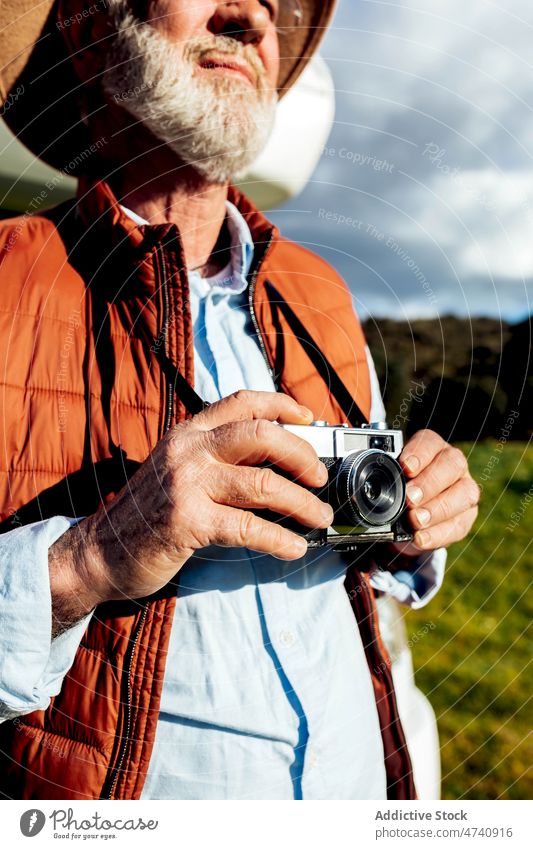 Anonymous man with photo camera in nature traveler photographer field trip hobby leisure journey beard grassy photography rural meadow summer male environment