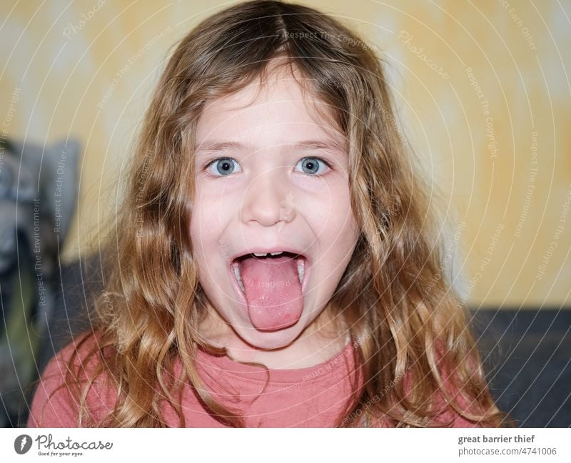 Girl with tongue out Child Infancy Looking into the camera curly hair Curl Schoolchild Evil facial expression Face Face of a child Forward Eye colour pout