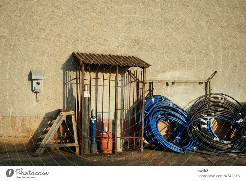 under lock Building Wall (building) depot Storage storage Evening Sunlight Closing time silent tranquillity Cable cable reels Gas cylinder Closure Enclosed