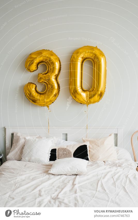 Helium balloons for 30 years above the birthday boy's or birthday girl's bed in the house. Festive morning wall room interior light modern decor decoration