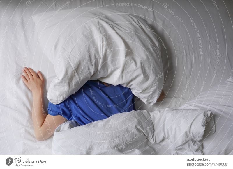 woman sleeping in bed with pillow over her head tired person sleepyhead late riser long sleeper lying hide face cover late sleeper unrecognizable block sunlight