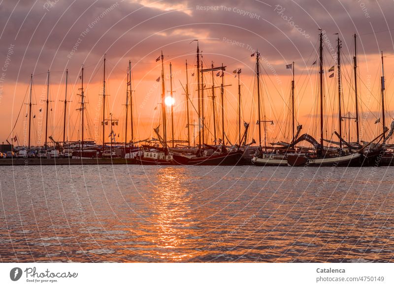 Sun sets behind the masts of the flat-bottomed ships Black Orange Harbour Adventure Water Ocean boat Navigation Maritime Environment daylight Climate Day