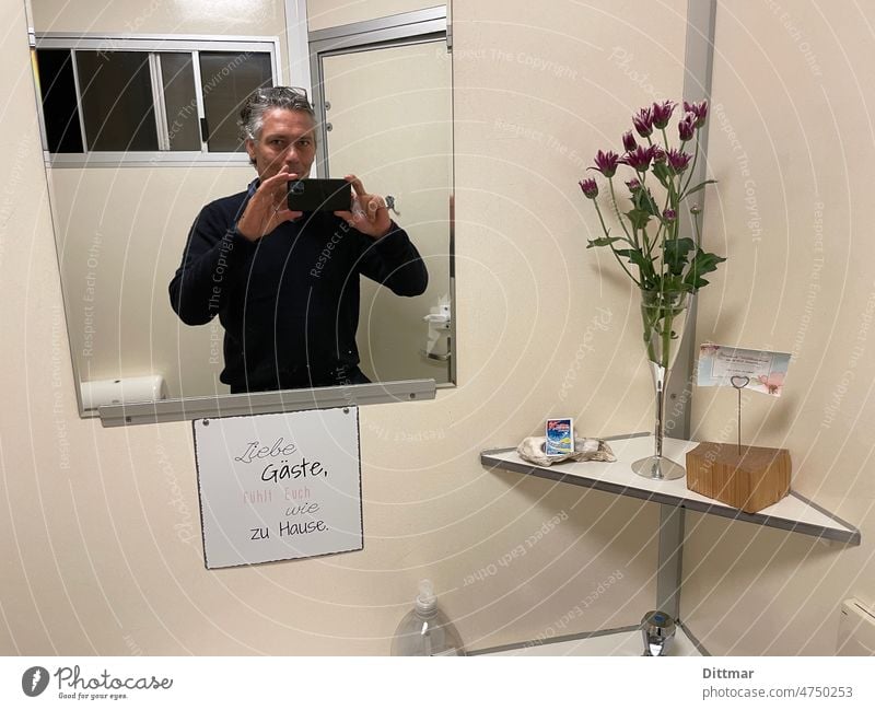 Man makes selfie in a lovingly designed campsite toilet Selfie Mirror Hospitality Camping site Toilet