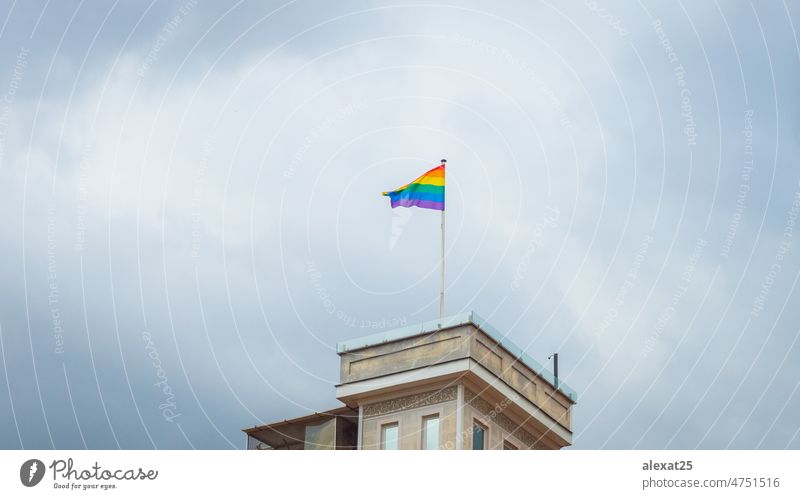Gay pride flag hanging on top of a building background banner bisexual blue celebration city clouds colorful community copy space diversity freedom gay green