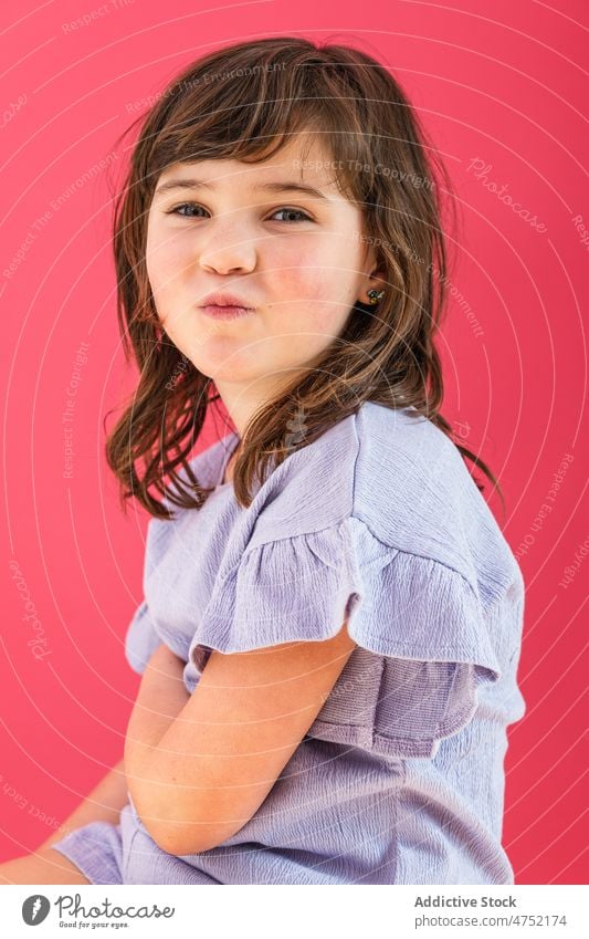 Cute girl pouting lips in bright studio portrait charming individuality gaze carefree grimace child make face appearance brown hair studio shot little kid funny