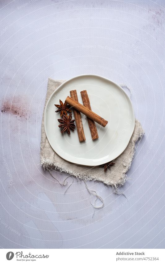 Ceramic plate with aromatic spices cinnamon anise star cloth linen table stick composition ceramic fabric natural organic ingredient dishware scent smell flavor