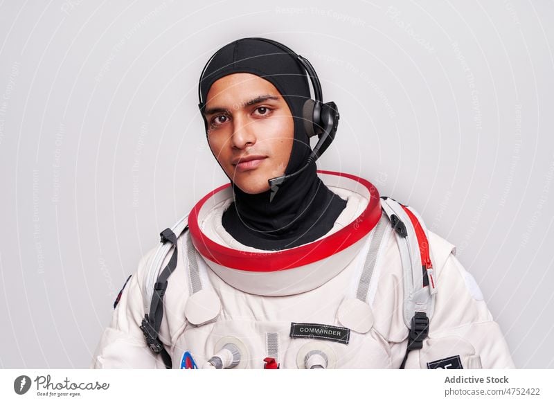 Serious ethnic astronaut in spacesuit with headset for cosmos flight man ready earth hispanic studio discovery prepare male portrait spaceman latin model