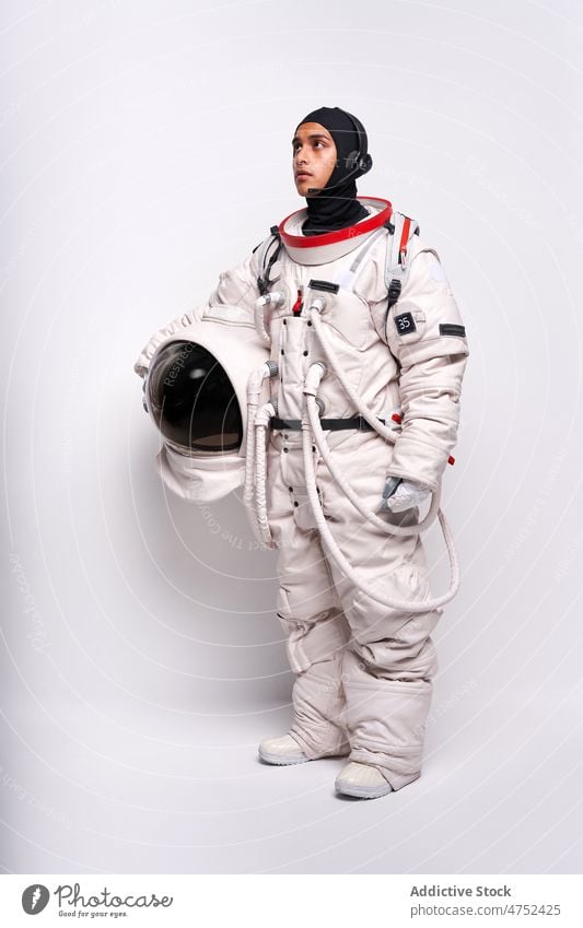 Serious ethnic astronaut in spacesuit and headset in studio man helmet safety astronomy mission appearance cosmos male cosmonaut model spaceman concept