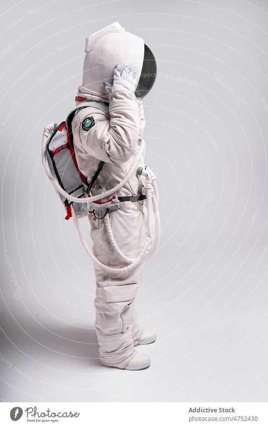 Astronaut taking off helmet of spacesuit in studio man cosmonaut cosmos take off safety protect universe astronomy male model astronaut visor person discovery