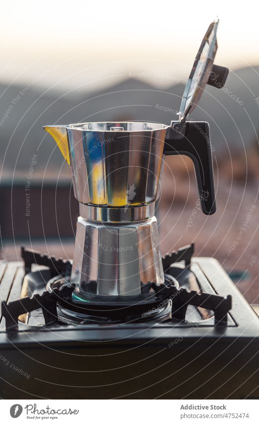 Stainless moka pot on gas burner in nature coffee stove geyser campsite prepare brew portable hot beverage fresh travel morning coffee maker cook utensil