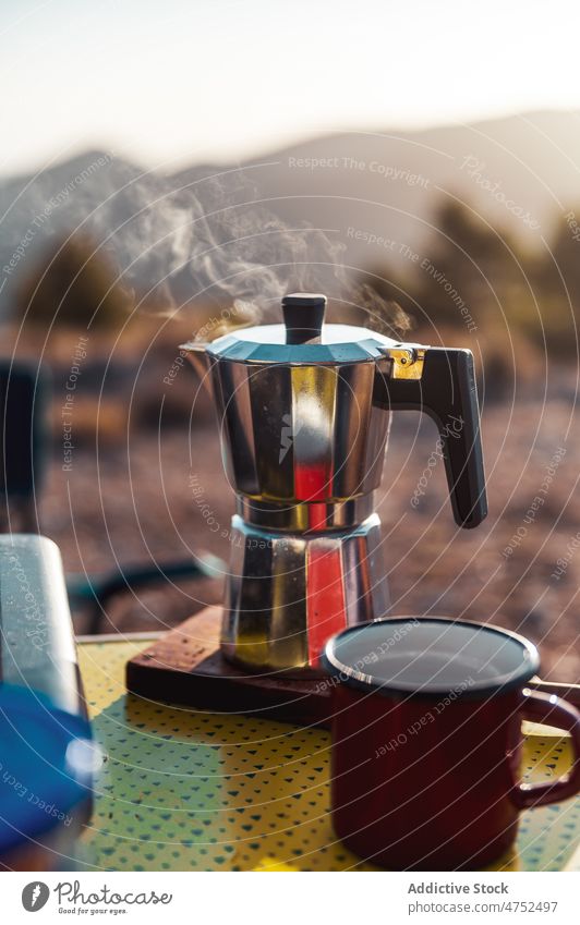 Aromatic coffee on moka pot in campsite hot breakfast brew morning explore person cup mug coffee maker journey beverage tourism camper caffeine travel geyser