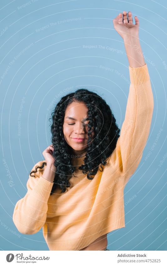 Smiling black woman with arms raised having fun appearance hairstyle feminine portrait eyes closed trendy happy studio attractive female charming