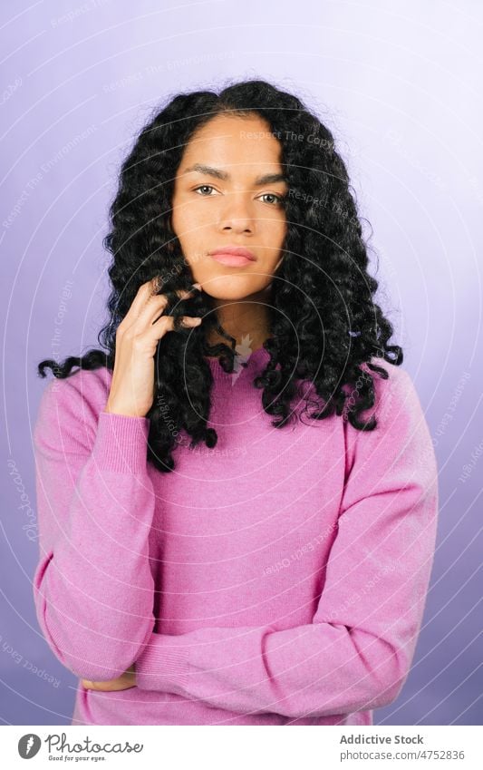 Pensive black woman looking at camera appearance hairstyle feminine trendy studio attractive female charming portrait african american lady beautiful light