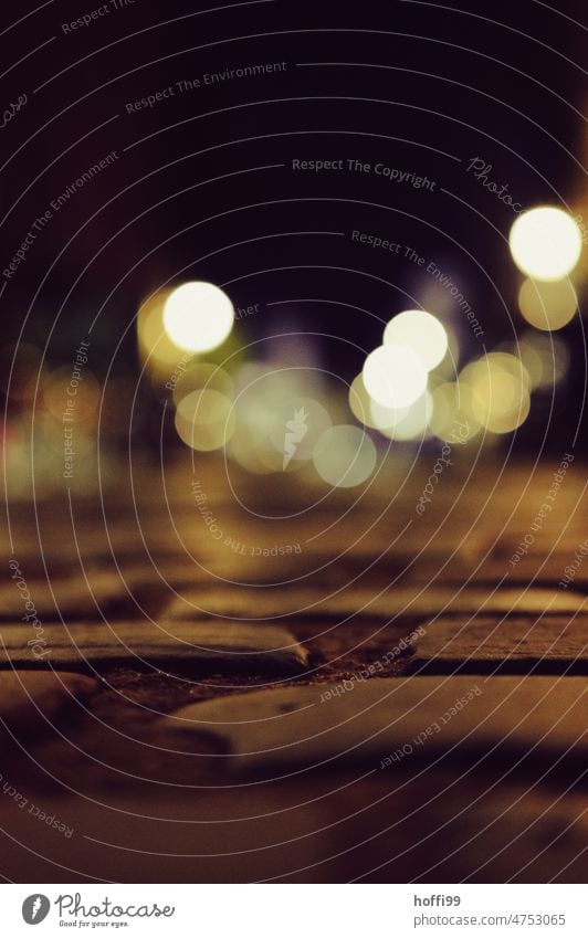 Light dots over paving stones at night Night life bokeh lights Bokeh background blurriness Abstract hazy Paving stone Street Round clearer circles defocused