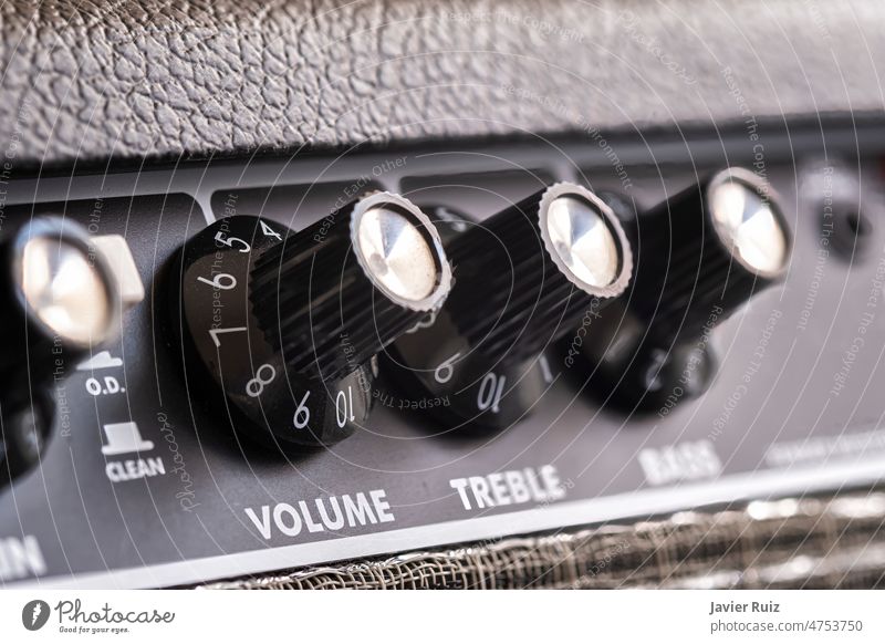 selective focus of the volume, treble and bass control knobs of a guitar amplifier, equalization dials close up equalizer EQ electric guitar acoustic black