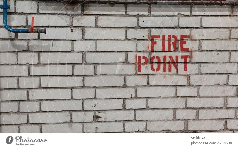 FIRE POINT" lettering on white brick wall fire point Fire sand-lime brick Wall (barrier) Tap Valve water pipe Fire prevention Caution Protection Fire department