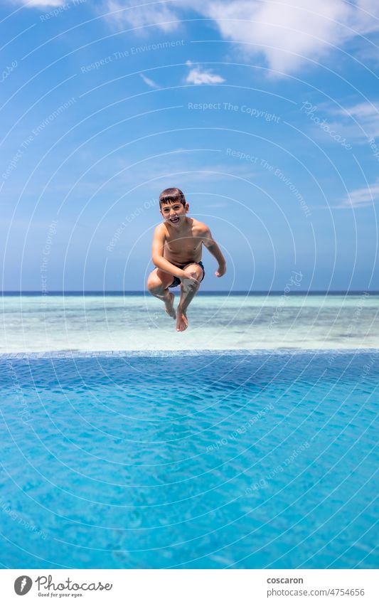 Funny kid jumping into a infinity swimming pool active baby blue blue sky boy child family fun funny happiness happy holiday hotel island joy landscape leisure