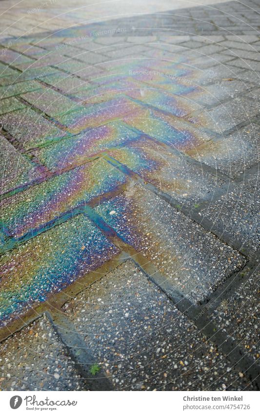 Colorful iridescent oil stains on the paved road Oil slick Cooking oil Environmental pollution Fluid Patch Fuel Poison Dirty Gasoline Diesel Abstract