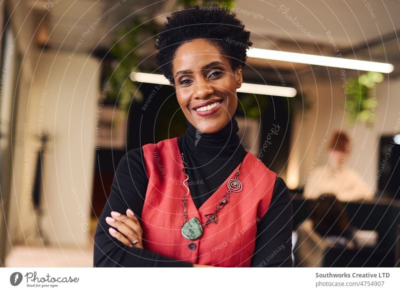 Portrait of cheerful mature black woman with arms folded looking at camera and smiling in coworking space empowerment portrait smile office indoors day one
