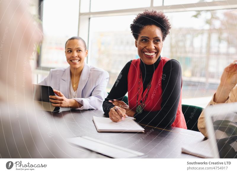 Portrait of cheerful mature black businesswoman listening and smiling with notebook in meeting room womens history portrait smile boardroom colleague teamwork