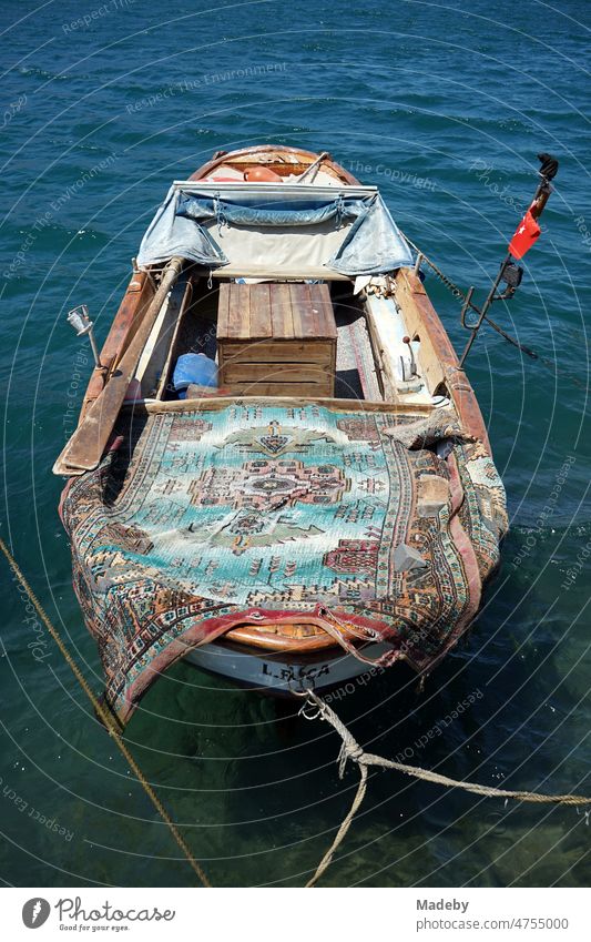 Old wooden fishing boat in summer sunshine in the harbor in the old town of Foca in Izmir province on the Aegean Sea in Turkey Returning home home port tourism