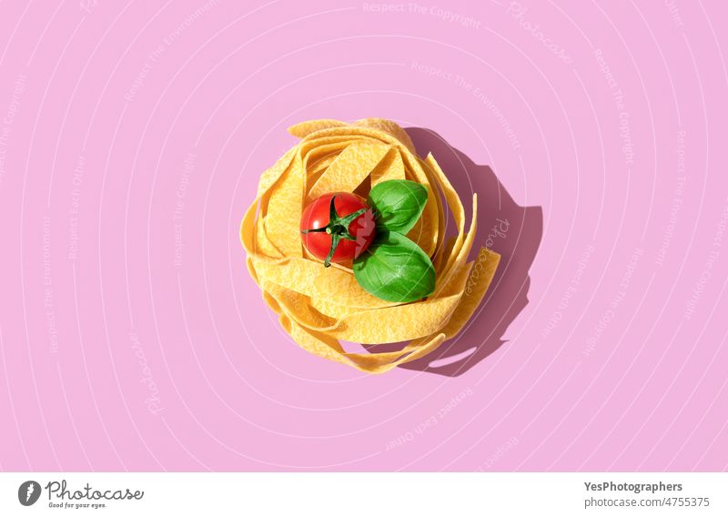 Pasta nest uncooked, top view on a pink background. above alfredo arrangement basil bright carbs cherry close-up color cuisine dry fettuccine food gourmet green