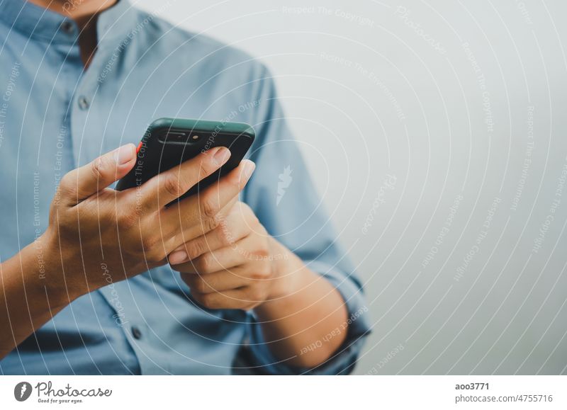 Close up of a man using mobile smart phone searching internet, sending sms, using text messenger or online banking.Copy space. mobile phone technology