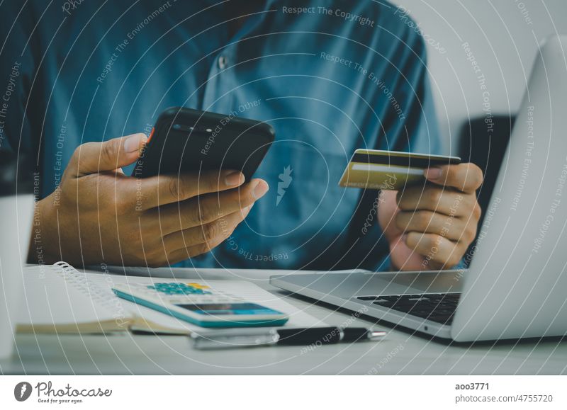 Man hand holds credit card and cell phone online shopping e-commerce and internet banking at desk. finance Credit Shopping Online Mobile Business Telephone