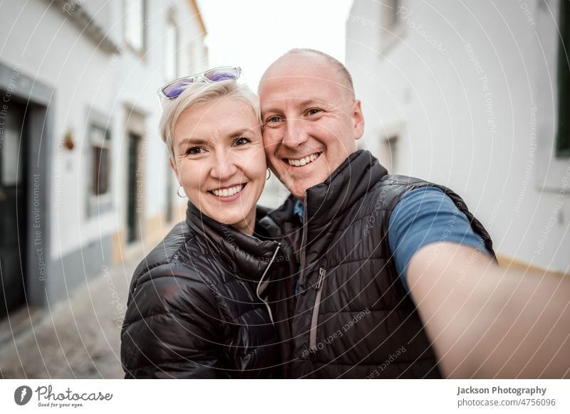 A selfie photo of a couple enjoying vacation in south Europe, Faro, Portugal standing casual attractive family two tourist friendship female caucasian smile