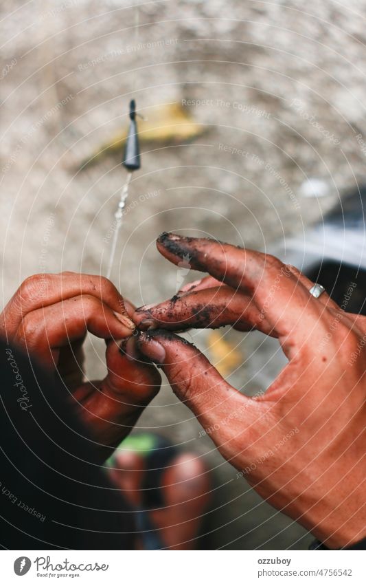 Close up dirty hand put bait worm on the hook. fisherman prepared for  fishing - a Royalty Free Stock Photo from Photocase