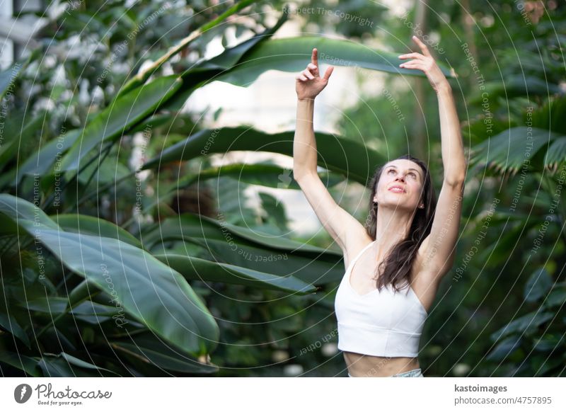 Female meditating and practicing yoga in tropical rainforest. Beautiful young woman practicing yoga outdoor with tropical forest in background meditation