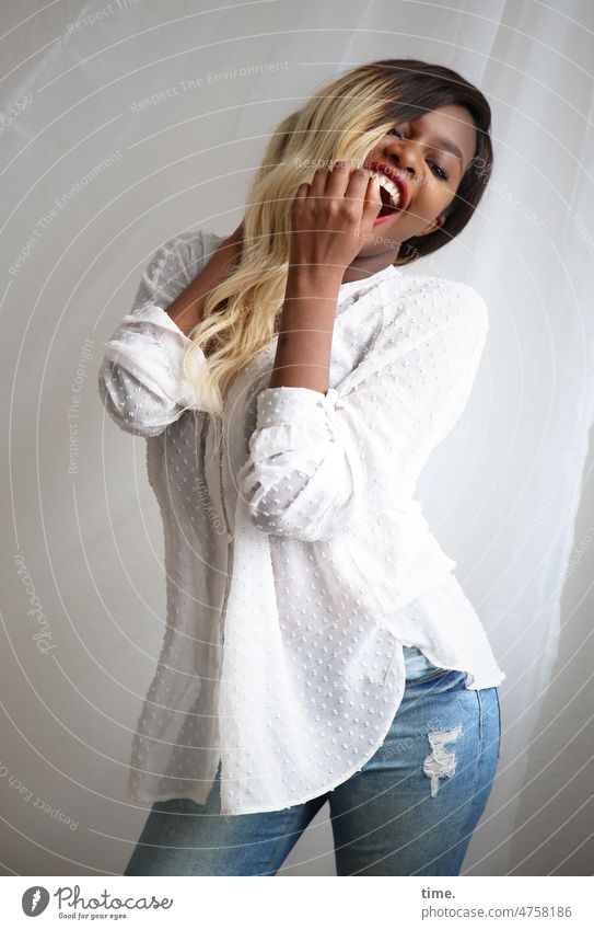 Woman in exuberant mood Laughter jeans Shirt Long-haired Blonde Drape Cloth Rag Curtain Stand stop Euphoric Movement Rotation portrait Front view