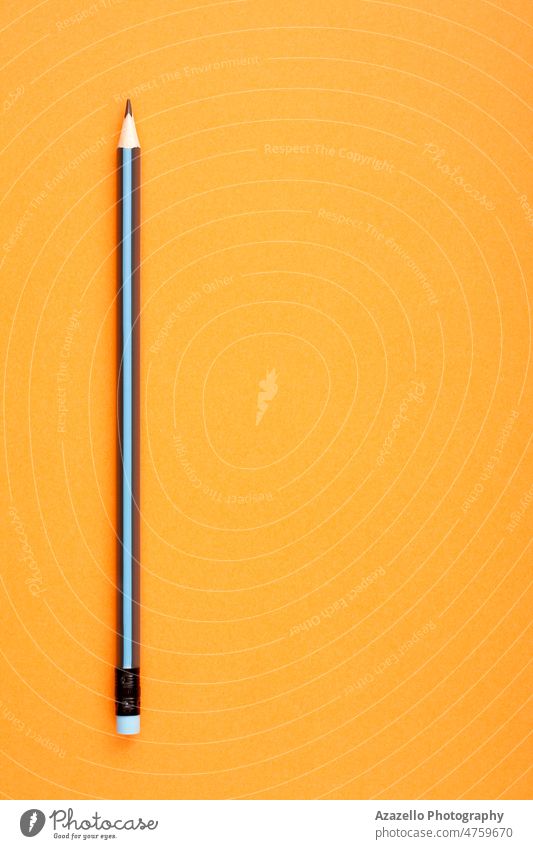 Black and blue pencil on orange background with empty copy space for text. art black blank blue color business closeup colorful concept creative creativity