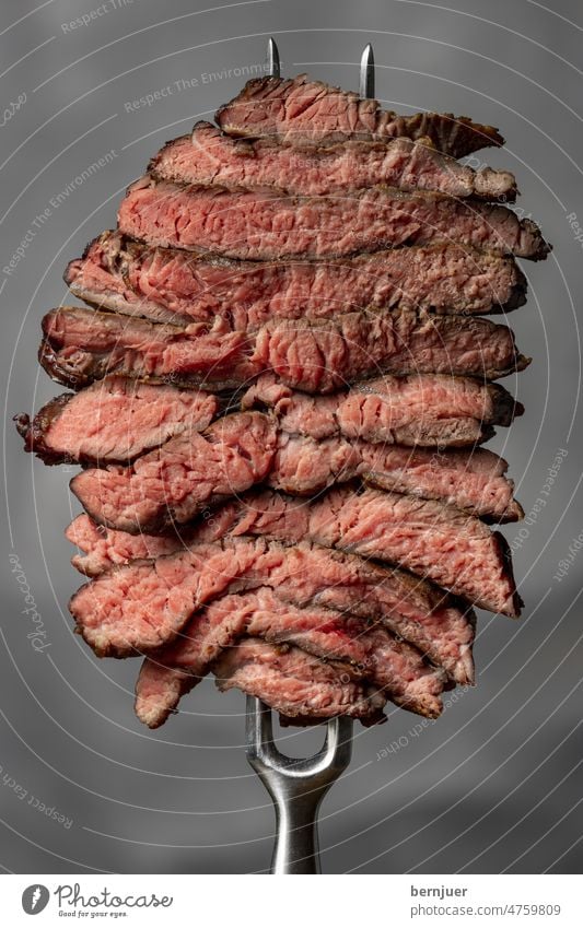 Slices of a steak on white background steak disc Carving fork Butcher Barbecue (apparatus) Impaled Kebab Fat grilled Meat Seldom White segregated sliced Fork