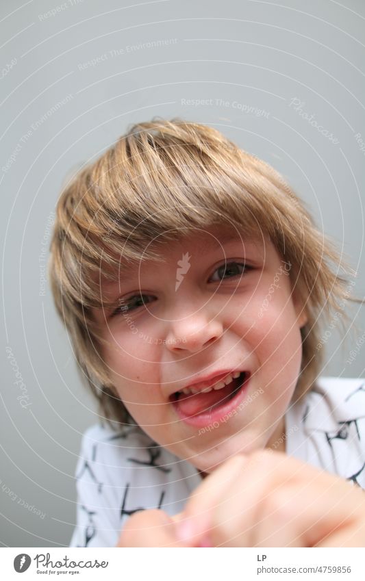 boy with tongue out looking down Joy Kindergarten real people Smiling Children's game Leisure and hobbies Optimism Close-up Love Connection Positive Innocent