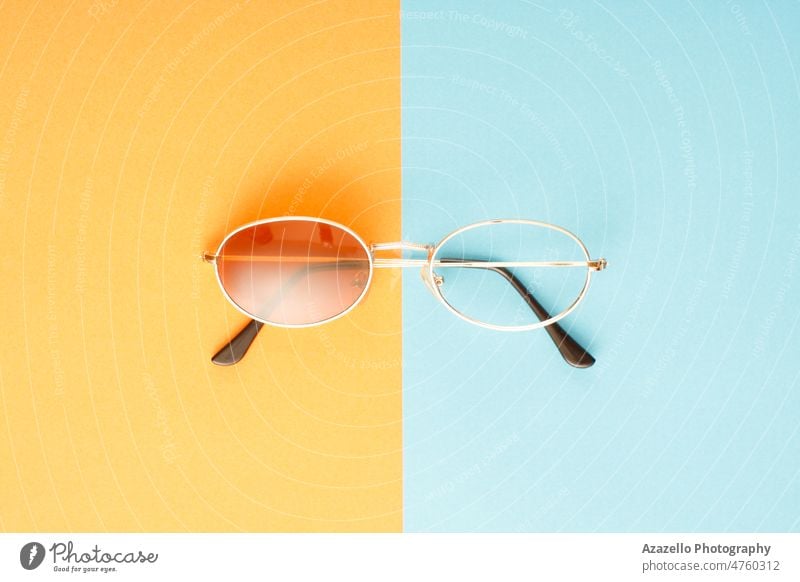 Defective sunglasses with missing lens on blue and orange background. accessories accessory closeup concept creative defective design eye eyeglasses eyesight