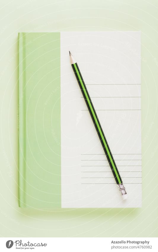 Green white notebook with a pencil. Business education minimalist concept flat lay. notepad paper draw paint business write notes office work plan planner