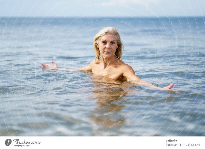 Mature woman in good shape bathing in the sea. mature beach swim active swimming senior old water person summer nature vacation female lifestyle healthy
