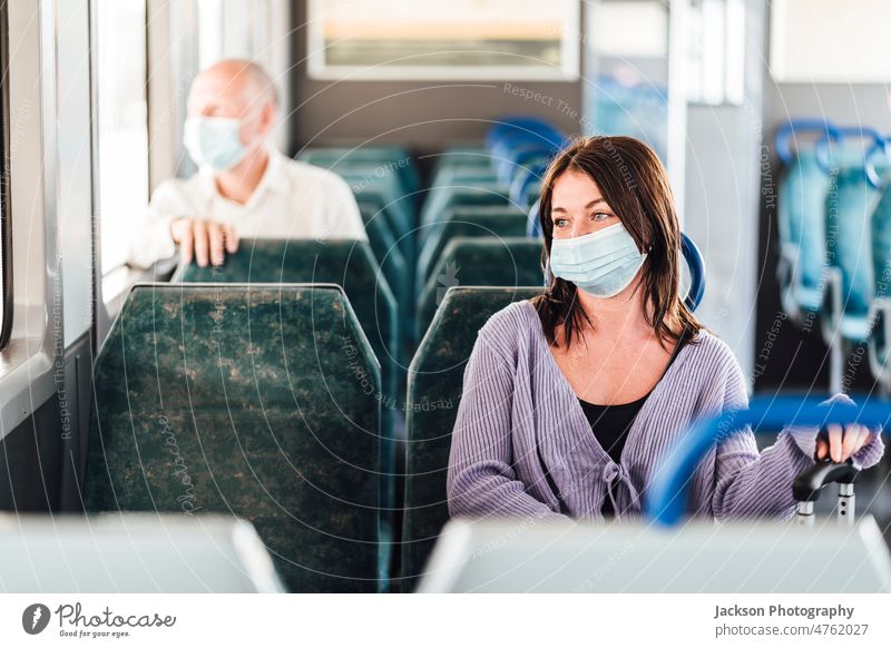 Serious passengers in protective masks during their train trip commuter serious sad depressed thoughtful luggage sit seat inside corona virus traveler modern