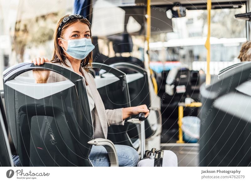 A young woman wearing mask commuting by the public bus traveler pandemic adult trip auto vehicle casual smile drive sitting happy journey attractive