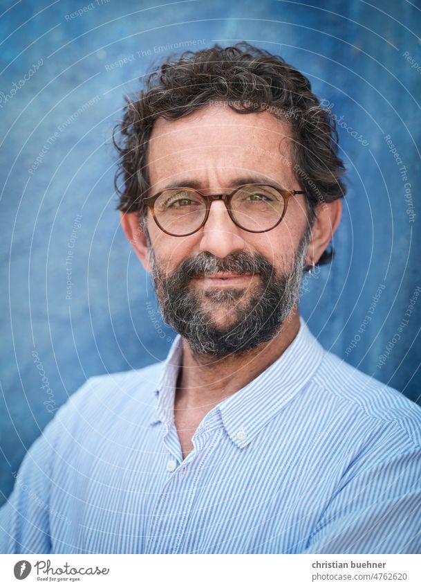portrait of 50 year old man - blue background Man 50 years likeable Earnest Model good-looking Reliability Eyeglasses Curl Blue background Facial hair