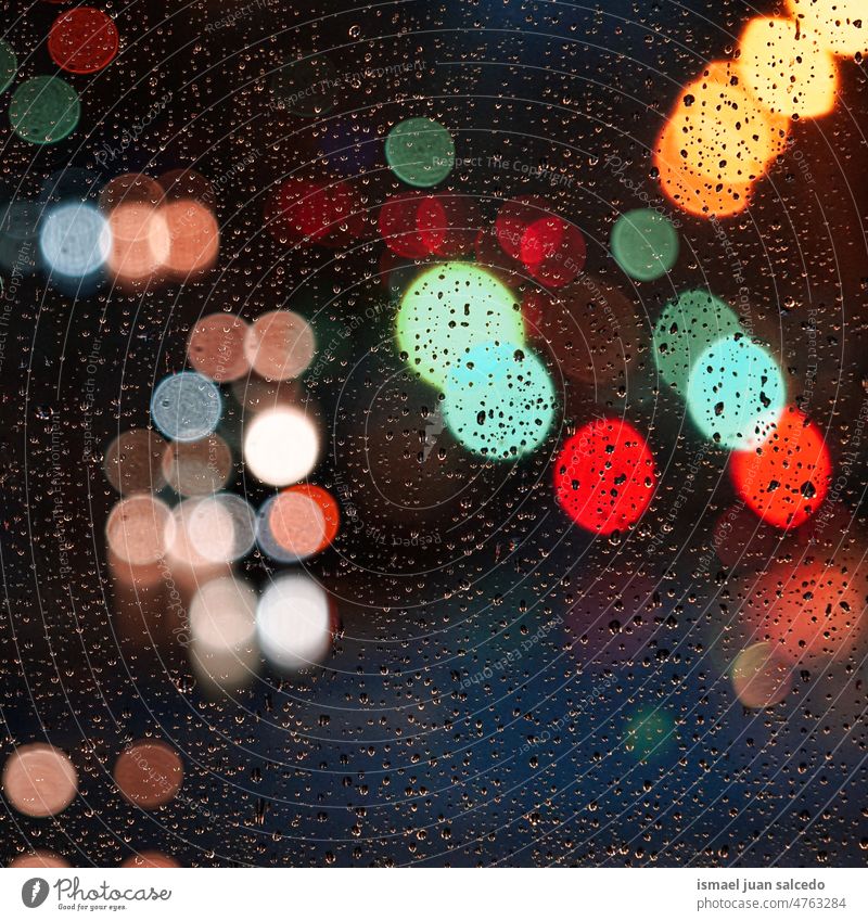 raindrops on the window and street lights at night backgrounds rainy glass colors colorful multicolored bokeh circles bright shiny blur blurred defocused city