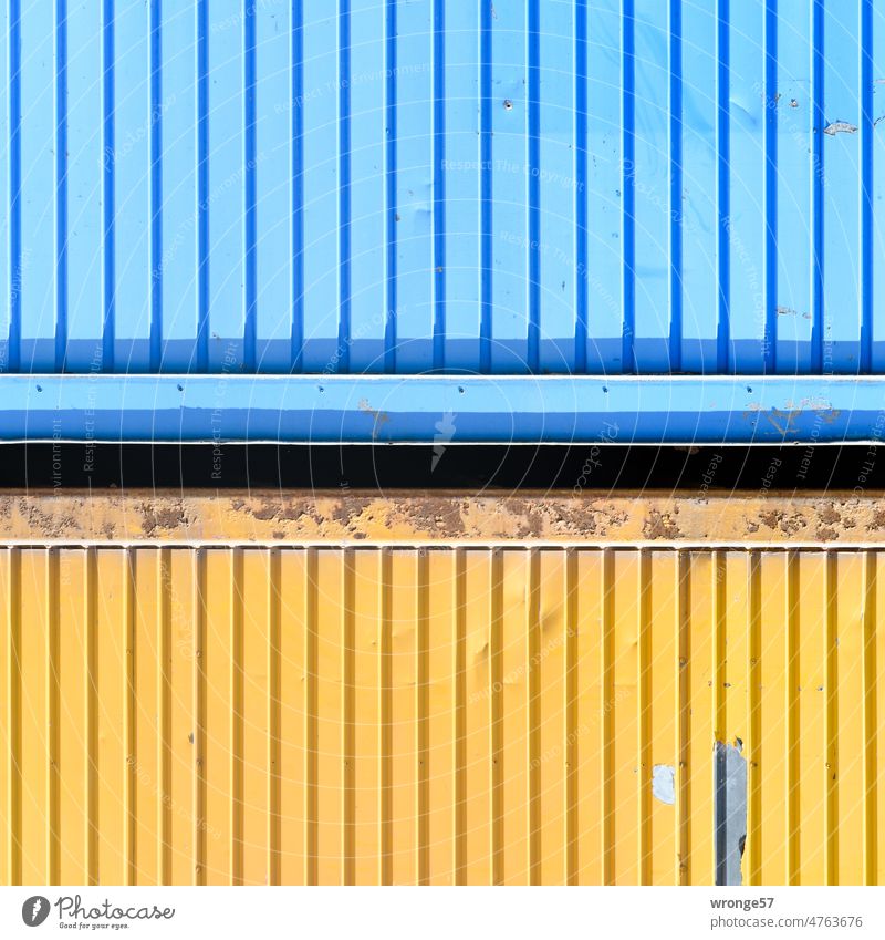 Close up of two containers stacked on top of each other Construction site Container overlying blue and yellow construction container Metal Exterior shot