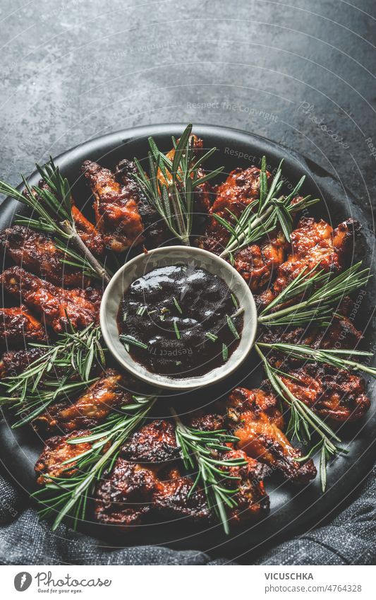 Homemade grilled chicken wings with bbq sauce and rosemary homemade dark concrete kitchen table delicious food marinated chicken meat top view american food