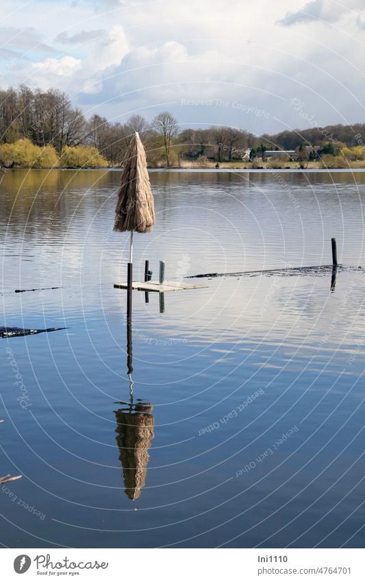 Parasol on flooded jetty into water Spring Landscape small moor lake Beautiful weather High water level Footbridge Water Sunshade Hawaii optics folded