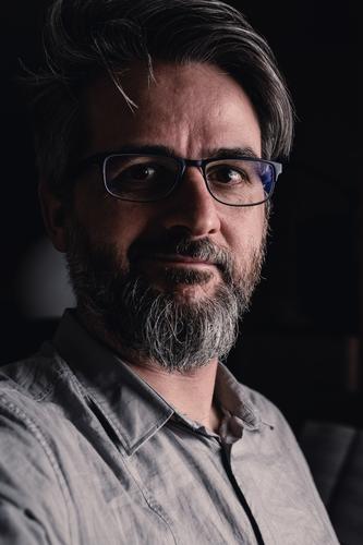 Portrait of man with glasses and beard smiling timidly Man portrait Dark Facial hair Shirt Eyeglasses grin Smiling Looking into the camera