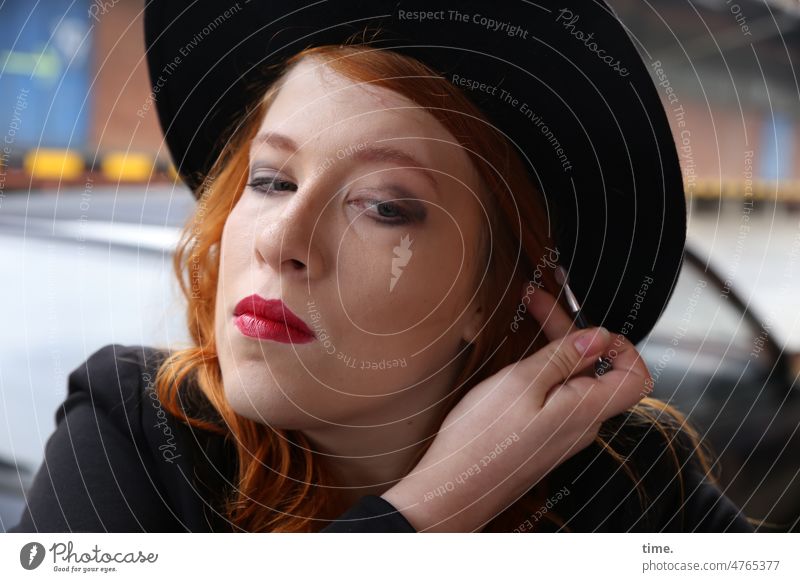 Woman putting on makeup Red-haired Hat Apply make-up Long-haired Concentrate Feminine Half-profile View to the side