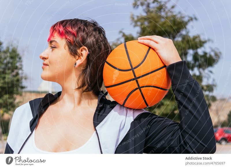 Female basketball player with ball on sports ground sportswoman streetball hoop goal game female sky summer hobby practice training activity lifestyle fit