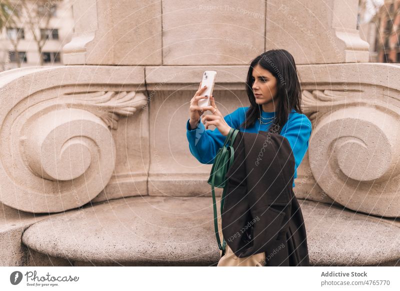 Woman taking selfie on street woman self portrait social media photography city urban smartphone feminine appearance trendy female town lady attractive light