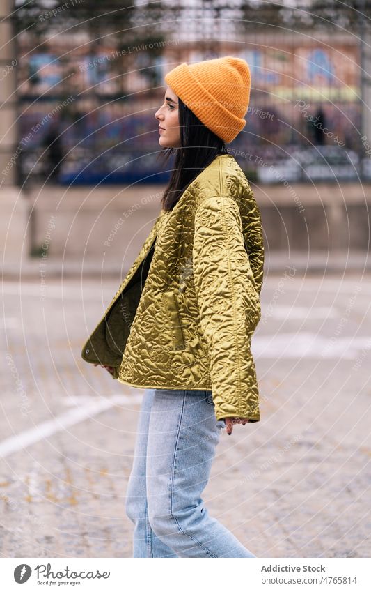 Positive woman in coat and beanie on street style city outfit trendy fashion urban appearance feminine female happy hat stylish headwear positive attire